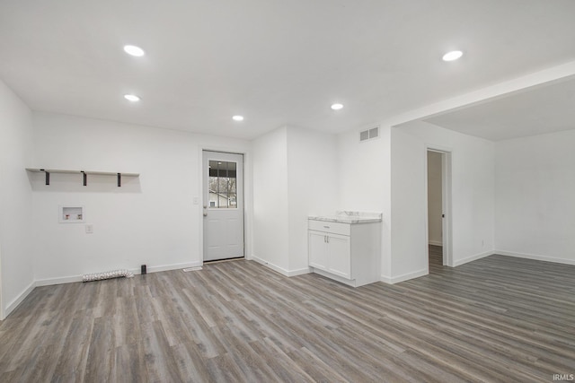 spare room featuring recessed lighting, wood finished floors, visible vents, and baseboards