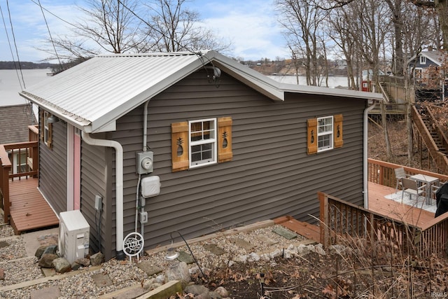 view of property exterior featuring metal roof and a deck