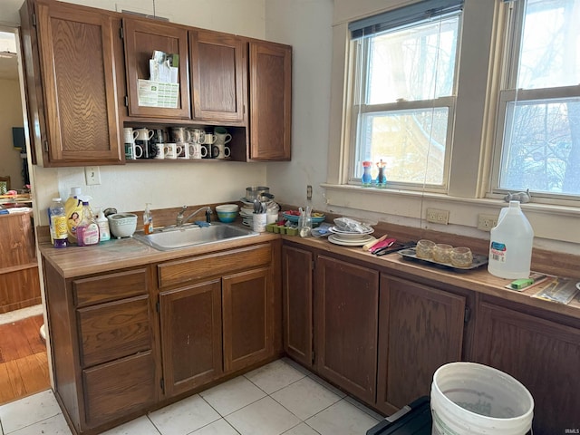 kitchen with a wealth of natural light, brown cabinets, light countertops, and a sink