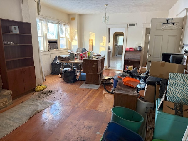 interior space with cooling unit, visible vents, washer / clothes dryer, a textured ceiling, and light wood-type flooring