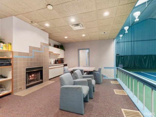 living area with visible vents, recessed lighting, a tile fireplace, and carpet