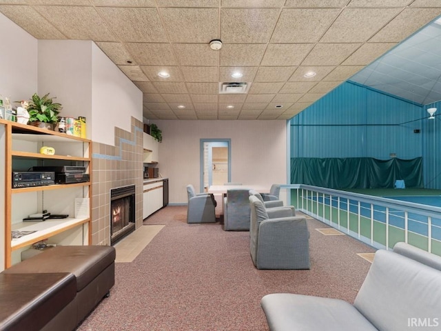 living area with visible vents, light carpet, recessed lighting, a tile fireplace, and a paneled ceiling