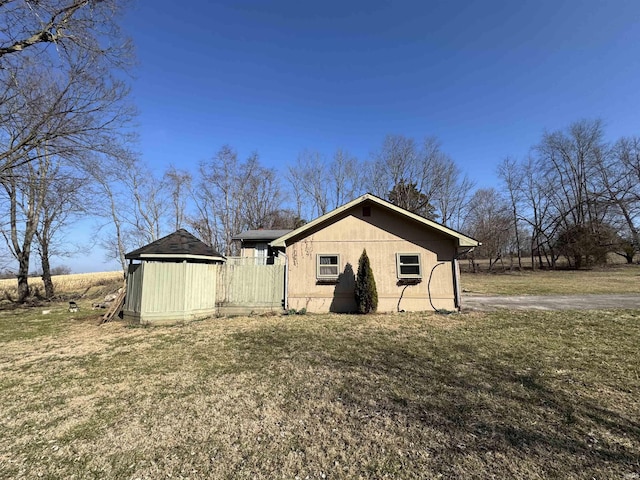 exterior space featuring a yard, a storage shed, and an outdoor structure