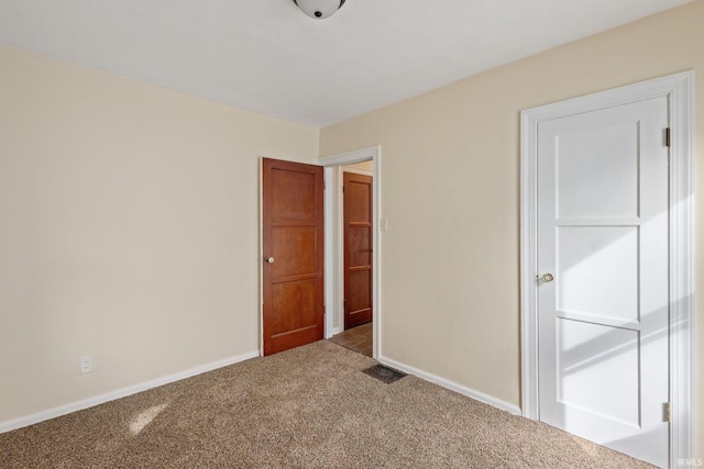 unfurnished bedroom featuring baseboards, visible vents, and carpet floors