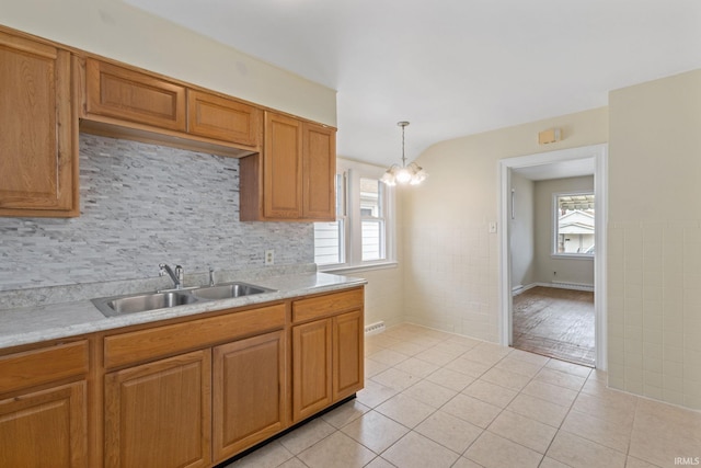 kitchen featuring light countertops, light tile patterned floors, plenty of natural light, and a sink