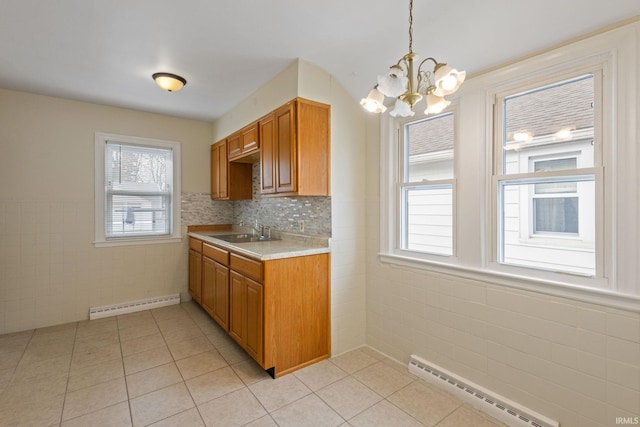 kitchen with light tile patterned flooring, a sink, light countertops, and a baseboard radiator