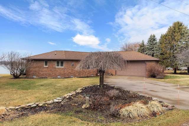 view of side of property with a garage, a lawn, driveway, crawl space, and brick siding