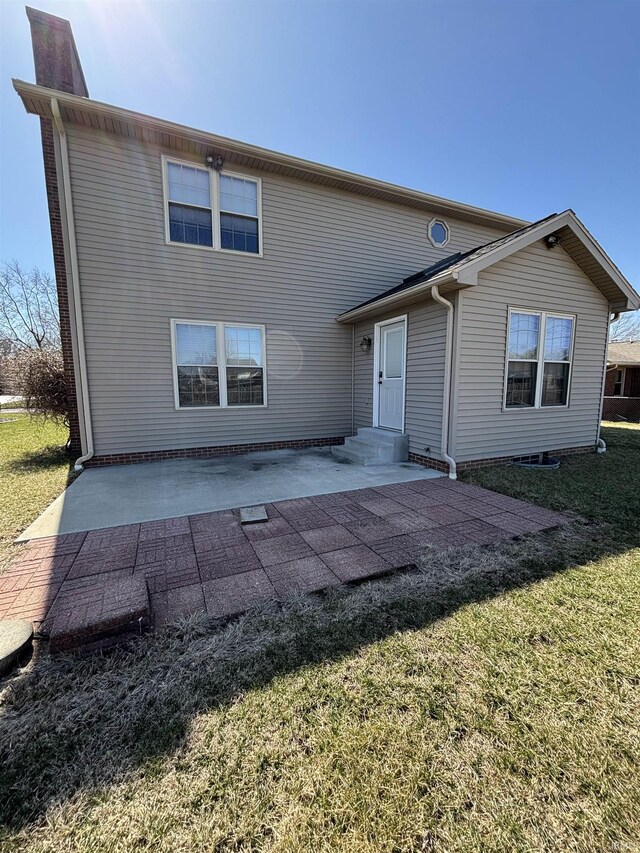 rear view of property featuring a yard, a patio, a chimney, and entry steps