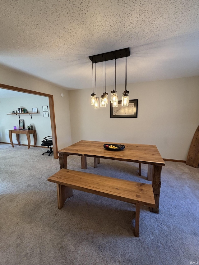 dining space with carpet flooring, a textured ceiling, and baseboards