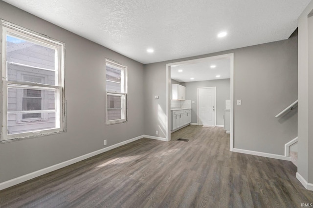 interior space featuring plenty of natural light, baseboards, and dark wood-style flooring