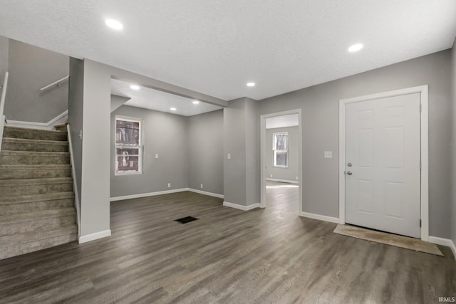 interior space with visible vents, baseboards, wood finished floors, and stairway