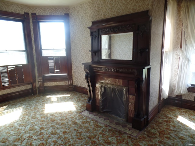 interior space with wallpapered walls, a fireplace with flush hearth, and baseboards