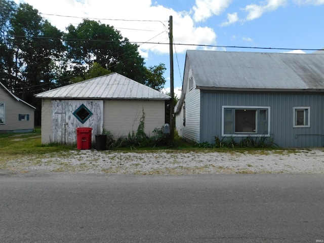 view of side of home with metal roof and an outdoor structure