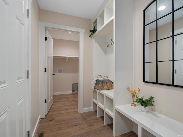 mudroom featuring visible vents, baseboards, and light wood-style flooring