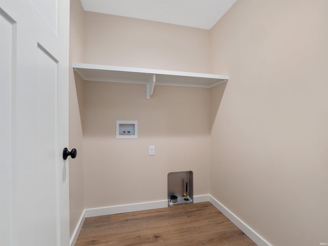 clothes washing area with washer hookup, laundry area, wood finished floors, and baseboards