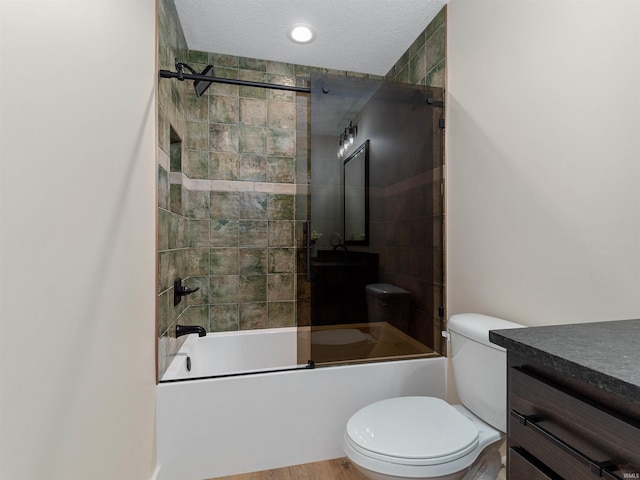 full bath with vanity, toilet, shower / bath combination with glass door, and a textured ceiling