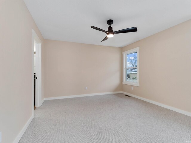 spare room with baseboards, light carpet, visible vents, and a ceiling fan