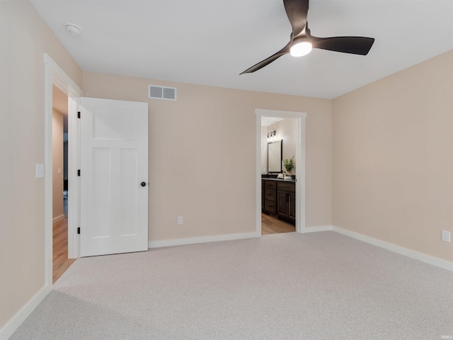 unfurnished bedroom with baseboards, visible vents, and light carpet