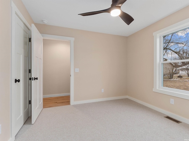 unfurnished bedroom featuring ceiling fan, carpet, visible vents, and baseboards