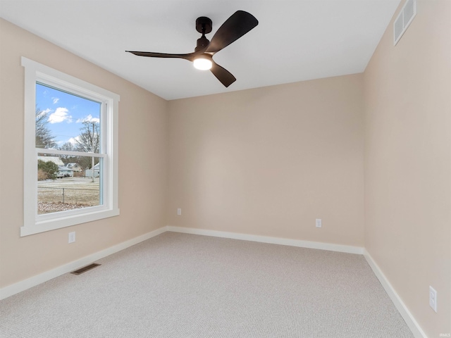 carpeted spare room featuring a ceiling fan, baseboards, and visible vents