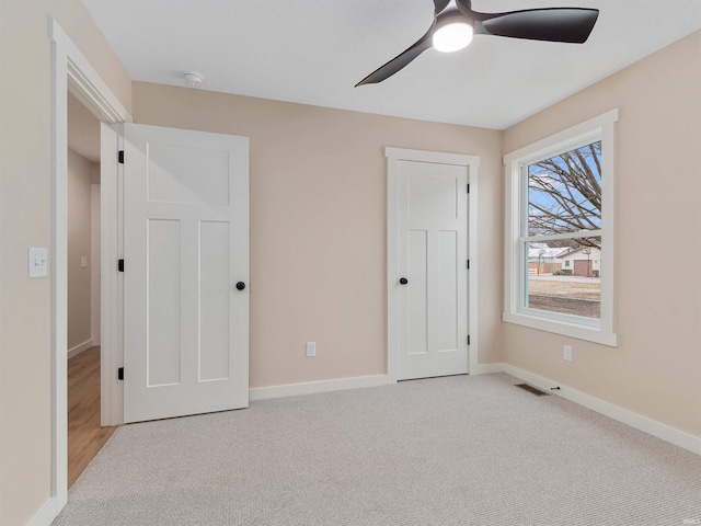 unfurnished bedroom with a ceiling fan, visible vents, carpet, and baseboards