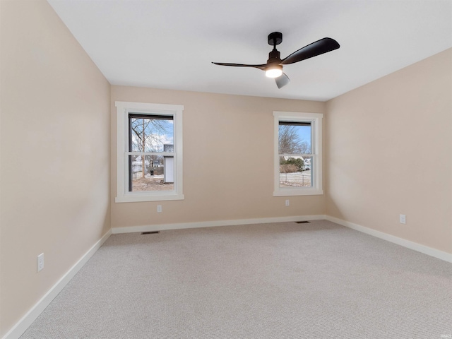 unfurnished room featuring a wealth of natural light, baseboards, and carpet