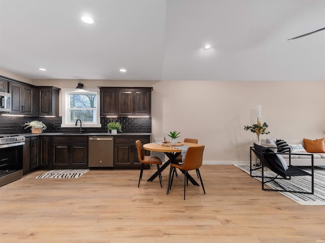 kitchen with a sink, backsplash, stainless steel appliances, light wood-style floors, and dark brown cabinetry