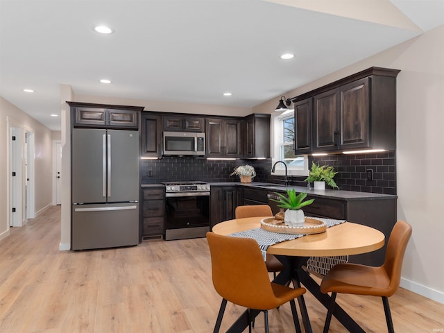 kitchen featuring a sink, dark brown cabinetry, light wood finished floors, and stainless steel appliances