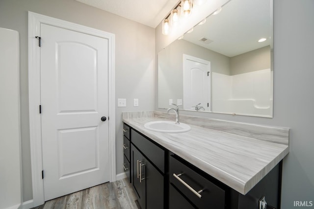 bathroom with visible vents, wood finished floors, and vanity