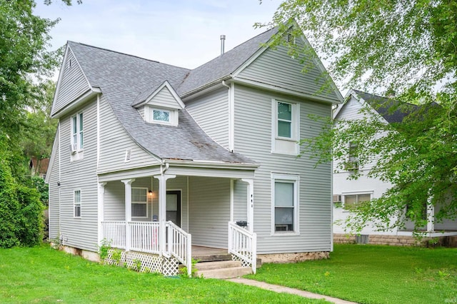 victorian-style house with covered porch, a front lawn, and roof with shingles