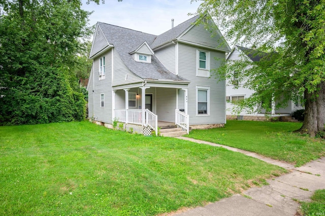 victorian house with a porch, a front lawn, and roof with shingles