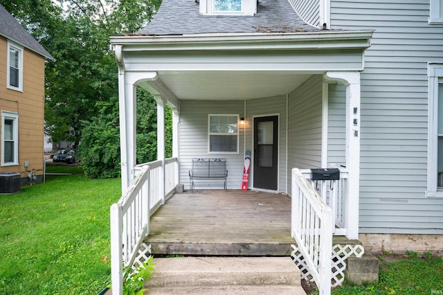 property entrance with a lawn, central AC, and a shingled roof