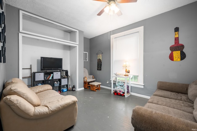 living area featuring ceiling fan, a textured ceiling, concrete floors, and baseboards