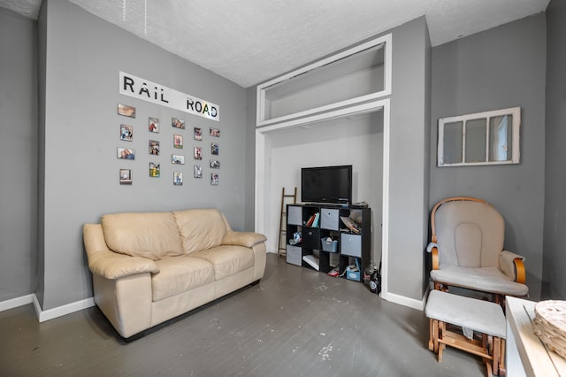 sitting room featuring a textured ceiling and baseboards