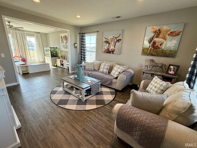 living area featuring dark wood finished floors, visible vents, and a healthy amount of sunlight