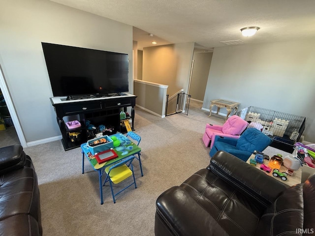 living area featuring carpet flooring, a textured ceiling, and baseboards