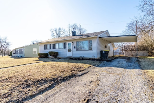 view of front of house featuring an attached carport, a front yard, and driveway