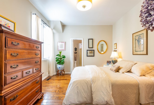 bedroom featuring hardwood / wood-style flooring and baseboards