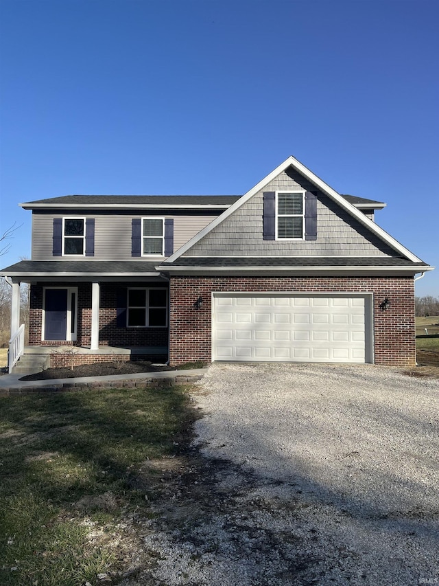 view of front of house featuring brick siding, covered porch, and driveway