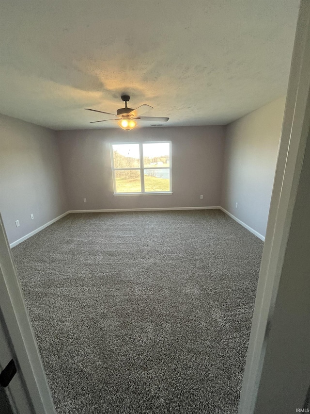 unfurnished room featuring a textured ceiling, baseboards, a ceiling fan, and carpet floors