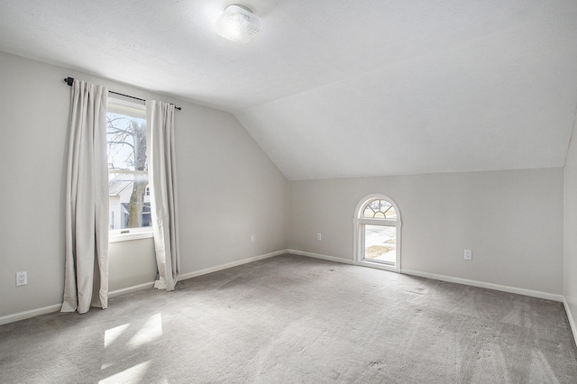 bonus room featuring a healthy amount of sunlight, baseboards, lofted ceiling, and carpet