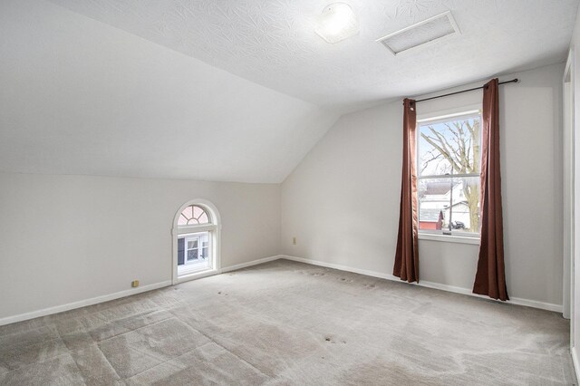 bonus room with visible vents, baseboards, vaulted ceiling, carpet flooring, and a textured ceiling