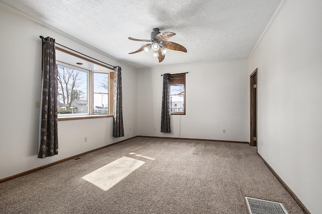 empty room featuring visible vents, a textured ceiling, carpet, and ornamental molding