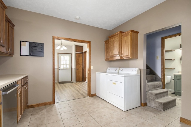 laundry room featuring washer and dryer, baseboards, cabinet space, and light tile patterned floors