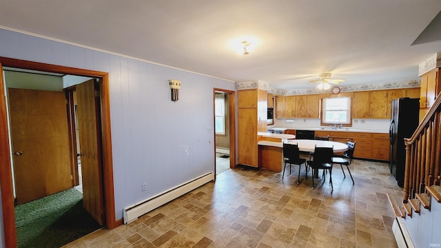 kitchen with light countertops, baseboard heating, brown cabinets, black appliances, and a baseboard radiator