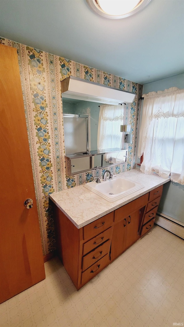 full bath with vanity, tile patterned floors, a shower with door, and baseboard heating