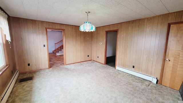 unfurnished room featuring a baseboard heating unit, stairs, visible vents, and carpet floors