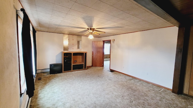 unfurnished bedroom featuring a ceiling fan, baseboards, carpet floors, and a baseboard radiator