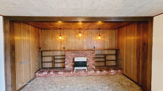 unfurnished living room featuring heating unit, wood walls, and carpet