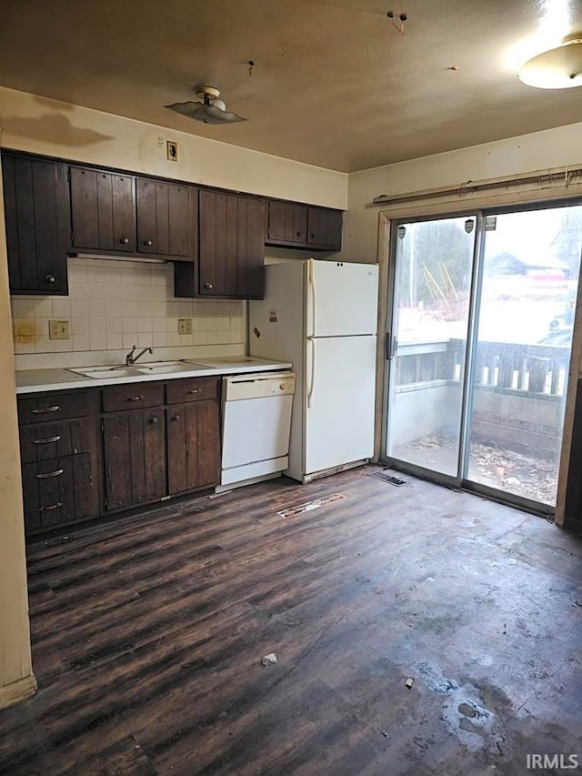 kitchen featuring a sink, tasteful backsplash, white appliances, dark brown cabinetry, and light countertops